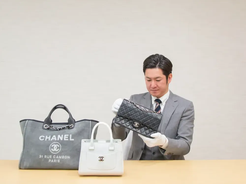 シャネルのバッグを2つ並べ、白い手袋で見比べている写真