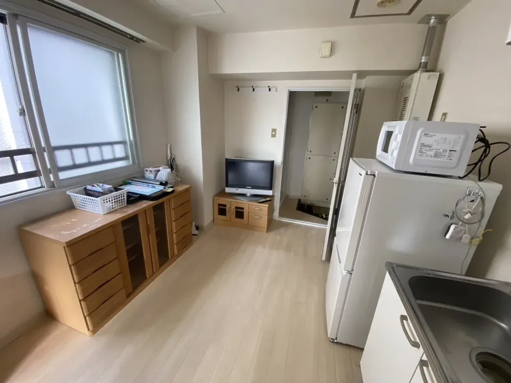 冷蔵庫・電子レンジ・テレビが置かれた部屋の写真